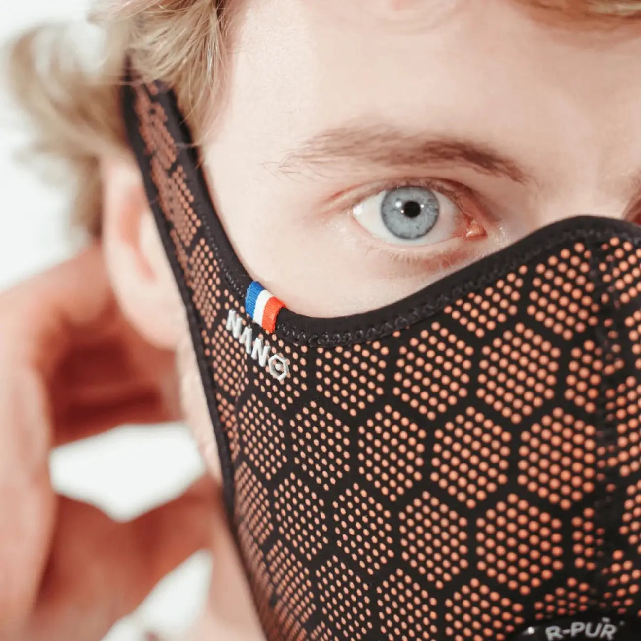 Man wearing a orange R-PUR mask, orange glasses and look in front.
