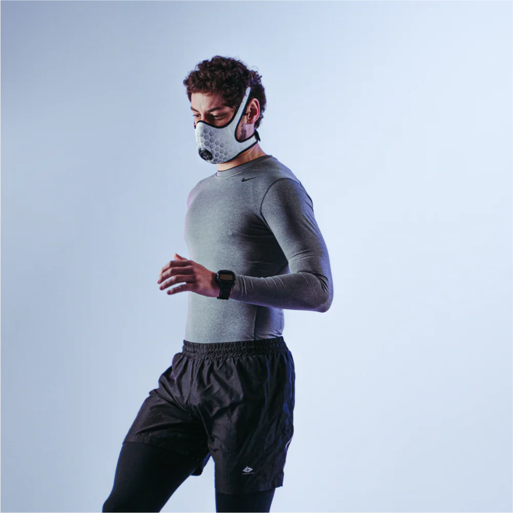 Runner wearing a white R-PUR running mask looking to the side and down