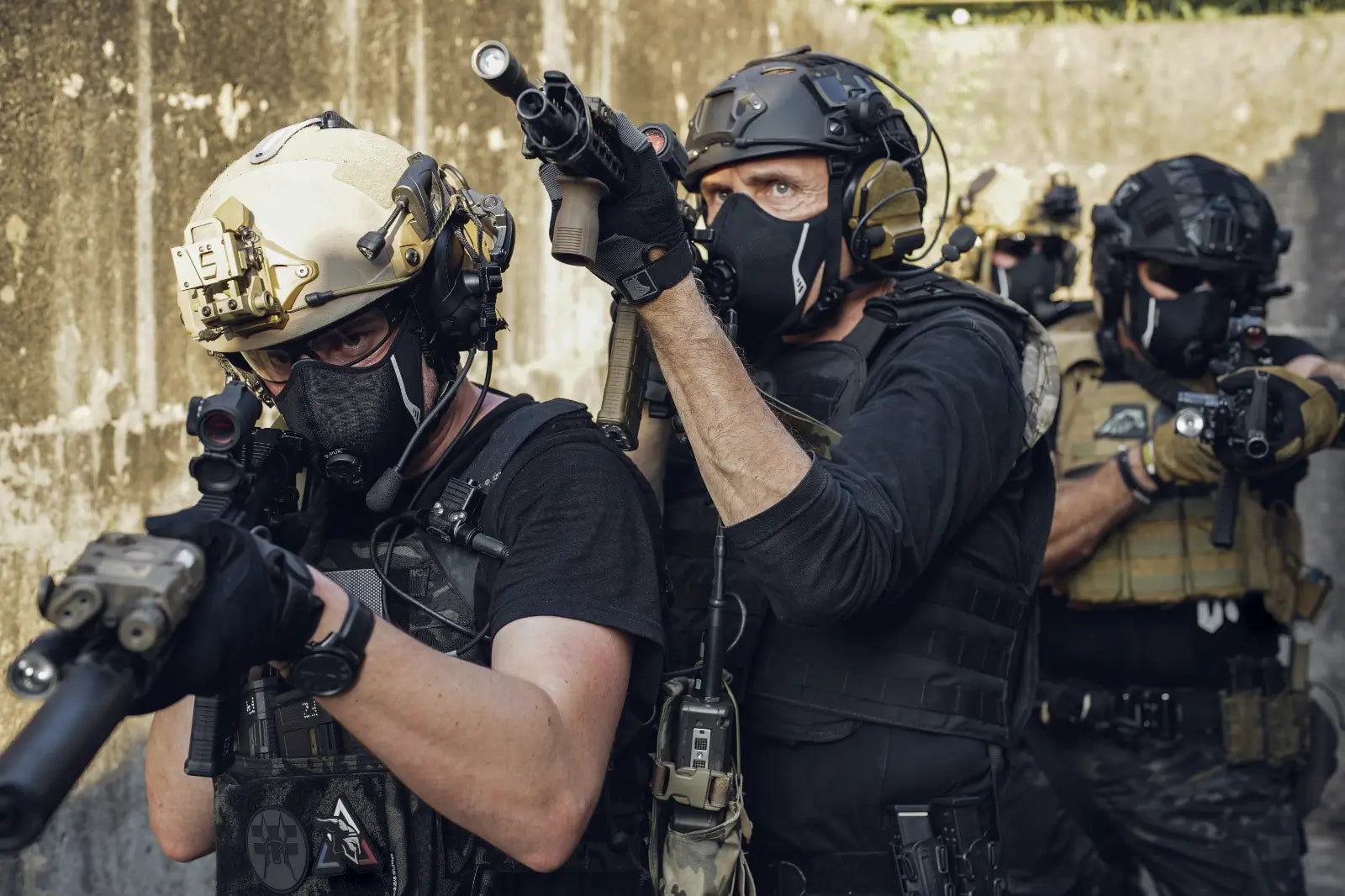 Group of shooters wearing respiratory protection masks during a shooting range training session, highlighting fit, stability, and compatibility with shooting equipment.